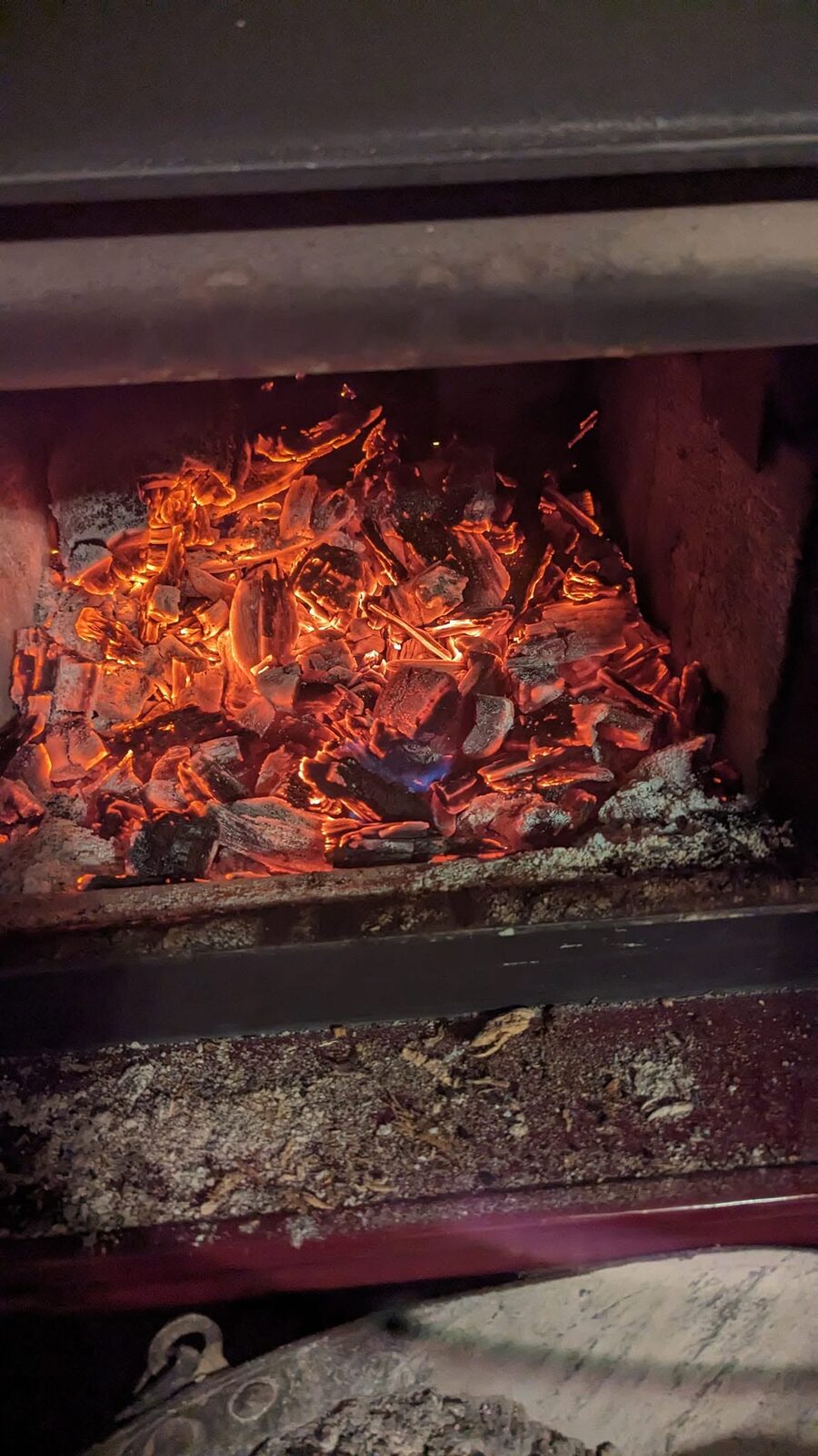 Glowing embers and ash inside a firebox