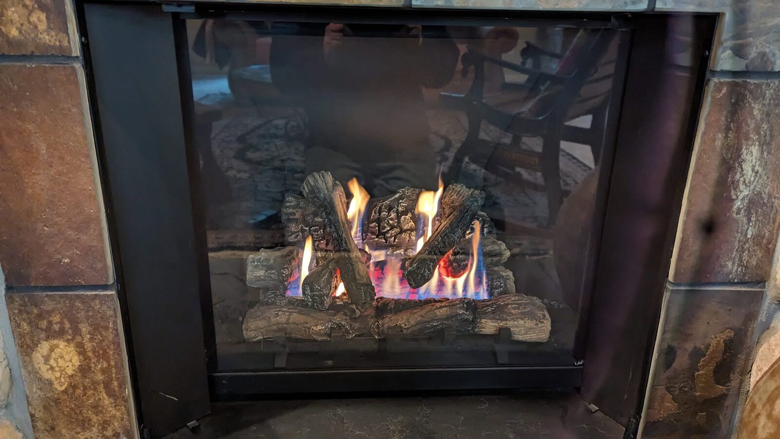 A gas fireplace burning behind glass doors
